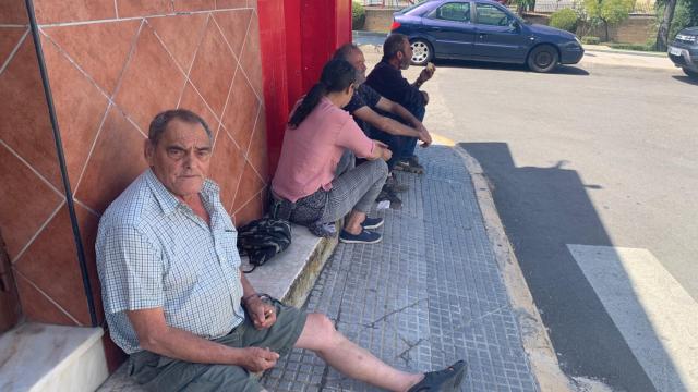 Unos vecinos de Burguillos, sentados a la sombra en una de las calles del pueblo.