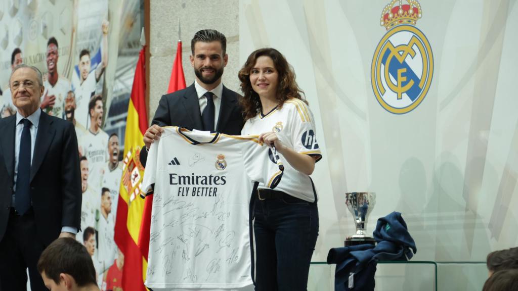Nacho Fernández posa con Ayuso con una camiseta del Real Madrid.