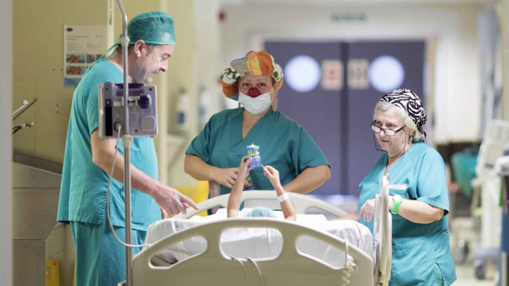 Uno de los payasos de Pupaclown acompaña a un niño a quirófano.