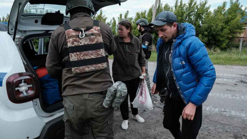Una familia de Vovchansk huye de la ciudad ante el avance ruso y los continuos ataques de artillería.