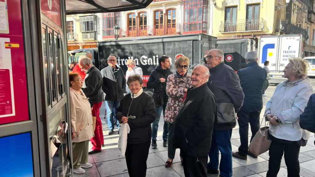 Lucía y su hermano esperando en la cola.