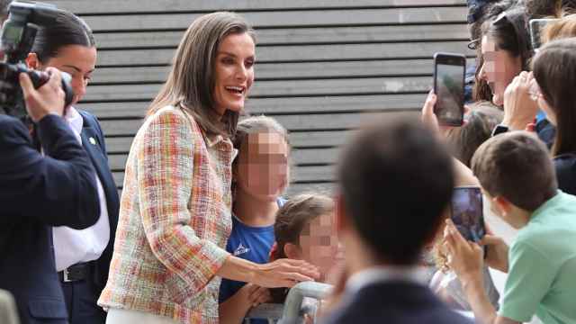 La Reina, rodeada de jóvenes a su llegada.