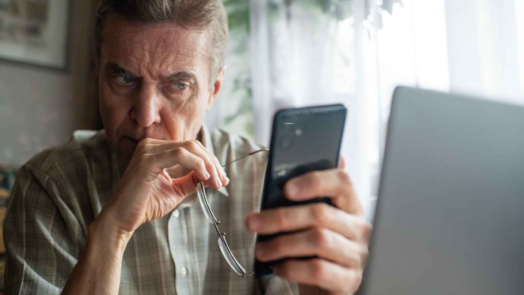 Un hombre mira preocupado su teléfono.