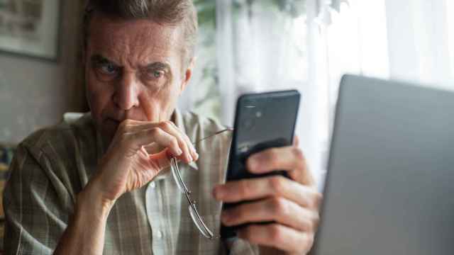 Un hombre mira preocupado su teléfono.