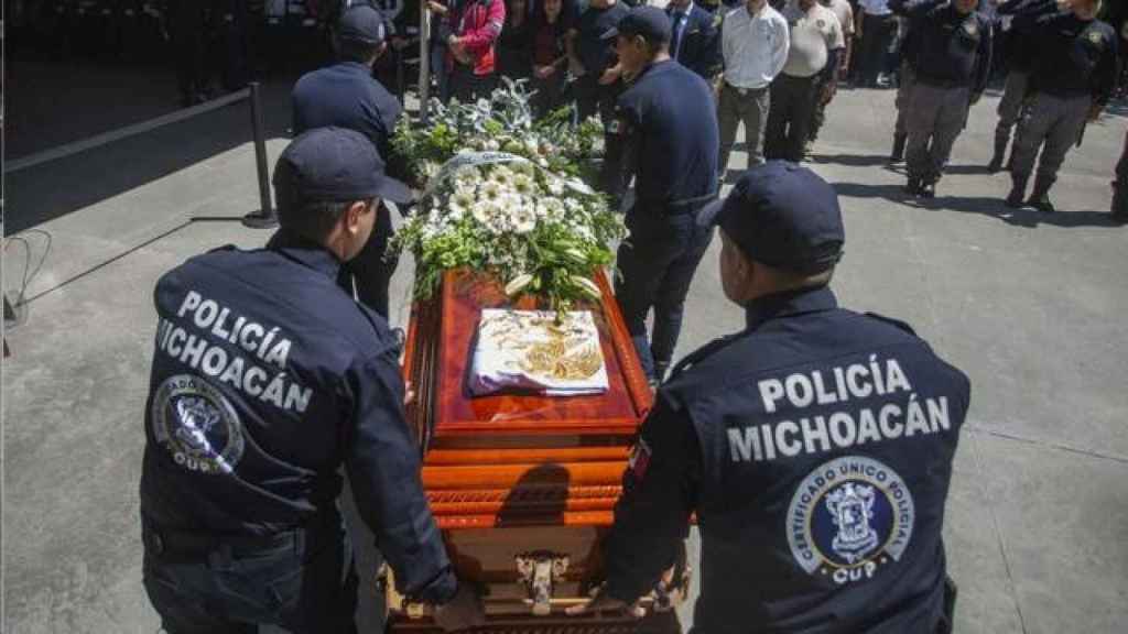 Policías en México trasladan el ataúd de un candidato asesinado en el estado de Michoacán.