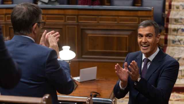 Pedro Sánchez, presidente del Gobierno, se aplaude mutuamente con Patxi López, portavoz del PSOE, en el Congreso.