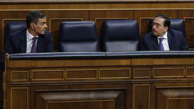 José Manuel Albares, ministro de Exteriores, charla con el presidente Pedro Sánchez en el pleno del Congreso.