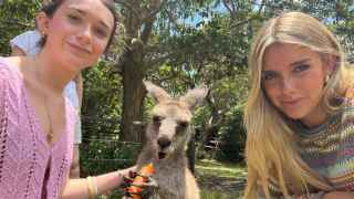 Paula junto a una amiga dando de comer a un canguro en Sídney