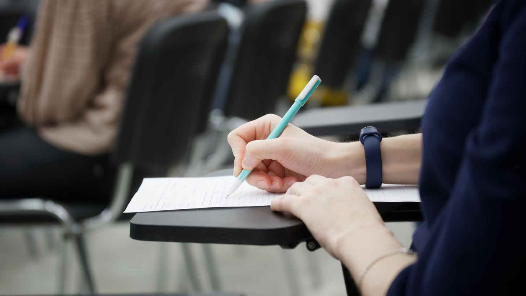 Una mujer escribiendo en un examen.