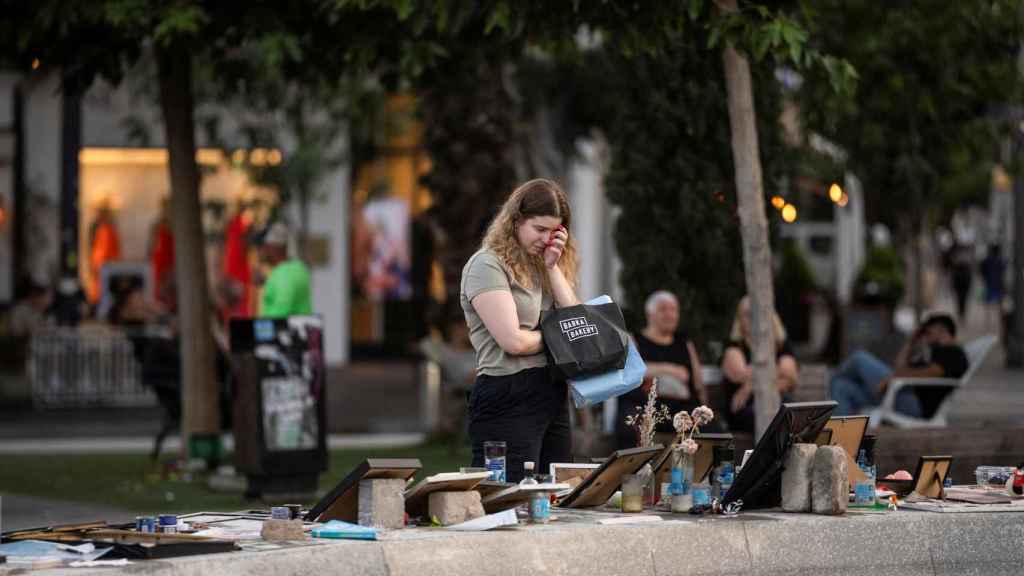 Una mujer mira las fotografías de los rehenes secuestrados por Hamás en Tel Aviv.