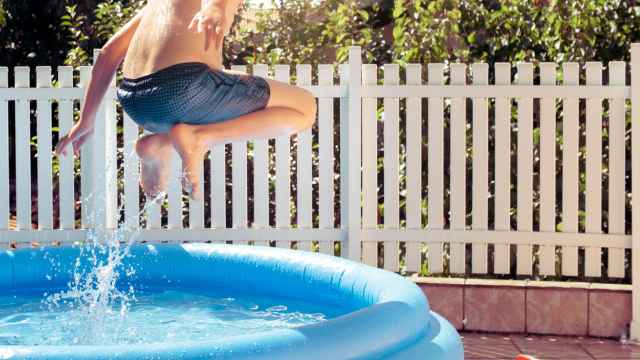 Un niño bañándose en una piscina en una terraza.