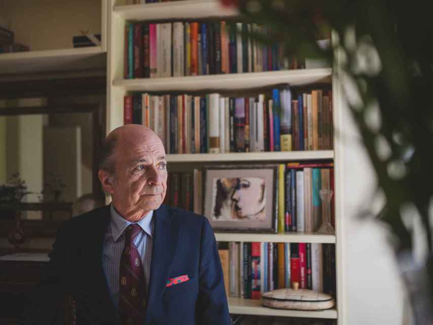 El profesor Rodríguez Braun, en su casa, con la biblioteca del recibidor de fondo.