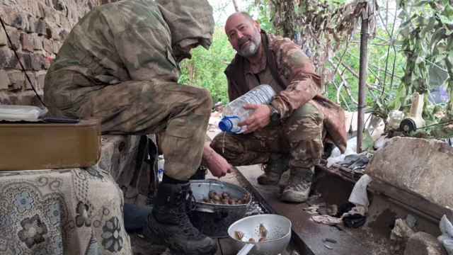 El valenciano Juan Manuel Soria, alias Simón de Monfort, a la derecha, prueba los caracoles que cocina para sus camaradas rusos en la posición defensiva.