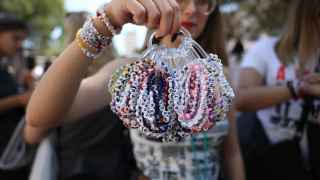 Una fan sostiene una colección de pulseras de Taylor Swift antes de su concierto en Lisboa (Portugal),