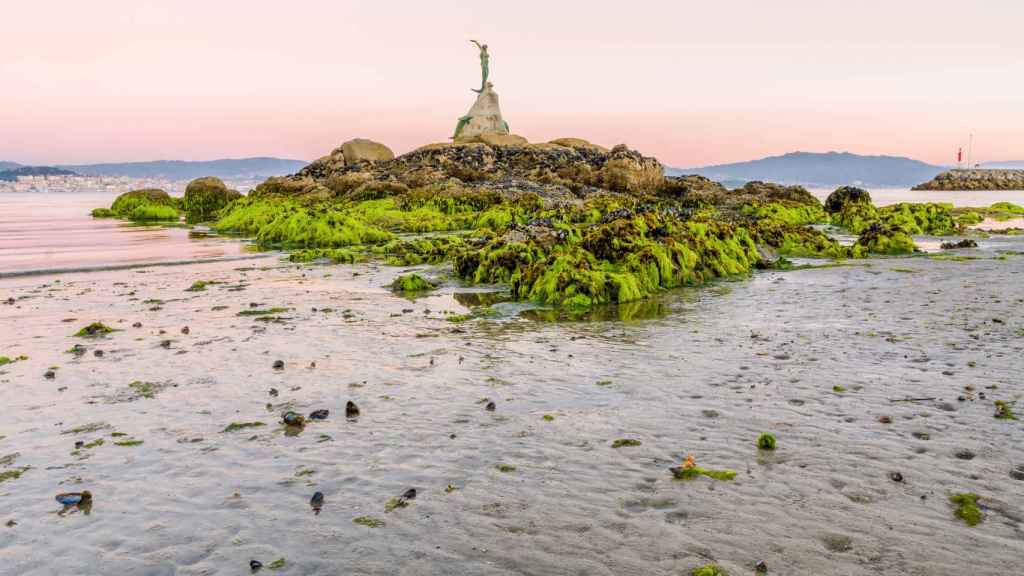 Vista de la escultura de la sirena de Cangas con la marea baja.