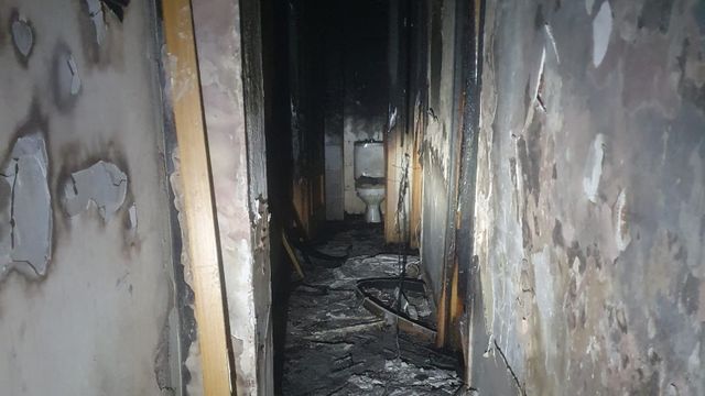 Pasillo de la vivienda afectada por el fuego y la densa humareda