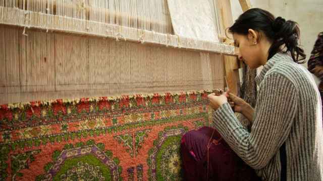 Una mujer trabajando en un telar.