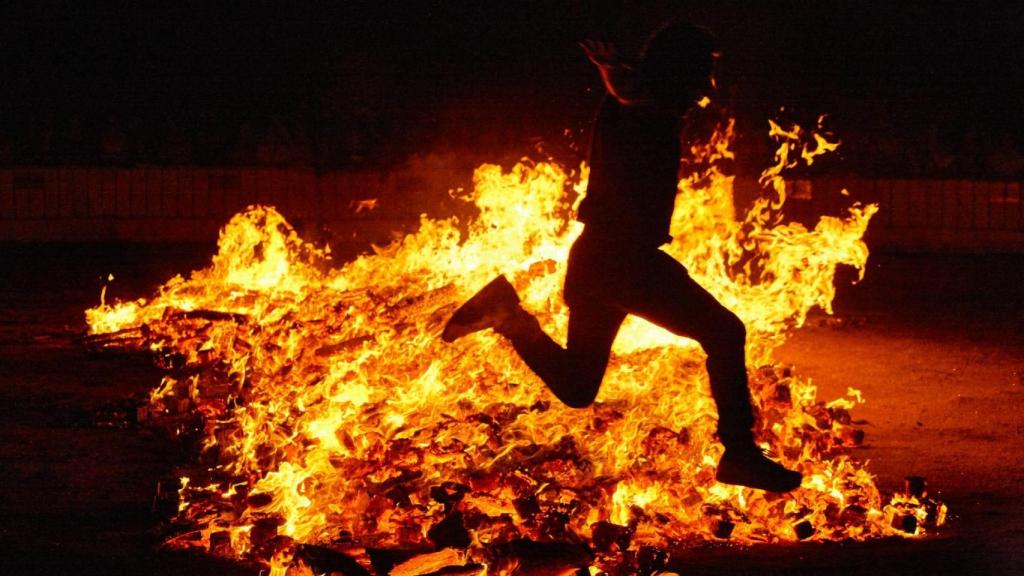 Una persona salta una hoguera en la noche de San Juan