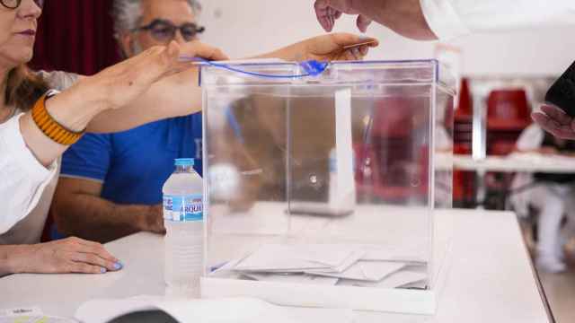 Un votante introduce su papeleta en la urna en el Colegio Maristas de Sevilla.