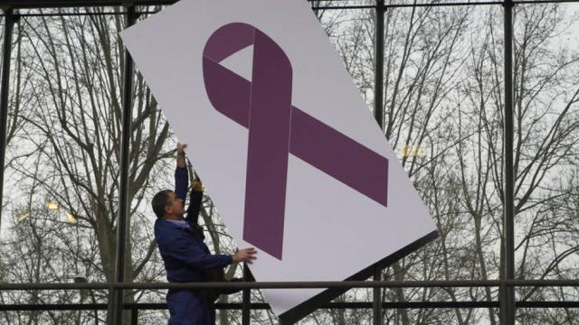 Un trabajador coloca un crespón morado en referencia a la violencia de género.