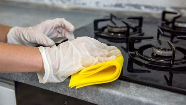 Imagen de una persona limpiando los fogones de gas de la cocina.