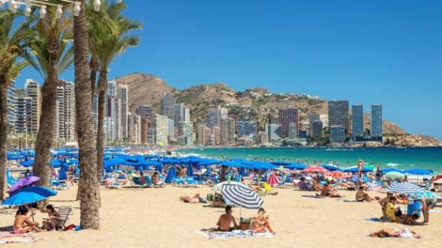 Vista general de una playa de Benidorm repleta de gente.