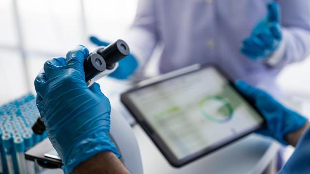 Científicos analizando resultados junto a un microscopio.