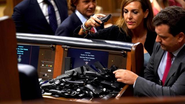 Varios diputados dejan los receptores en el escaño de Pedro Sánchez en señal de protesta.