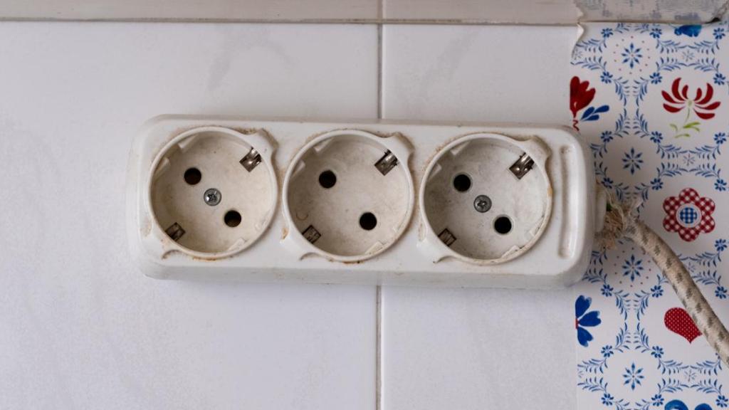 Tres enchufes con suciedad y tono amarillento.