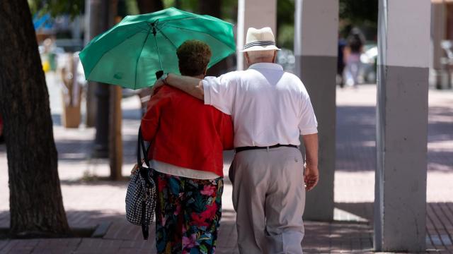 Una pareja de jubilados paseando por la calle.