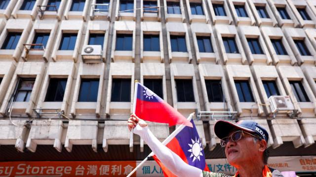 Un seguidor del partido Kuomintang ondea una bandera de Taiwán en las afueras del Parlamento.