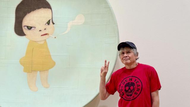 Yoshitomo Nara posando ante una de las piezas de la instalación. Foto: Erika Ede