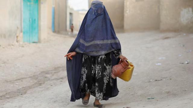 Imagen de archivo de una afgana mientras recoge agua.