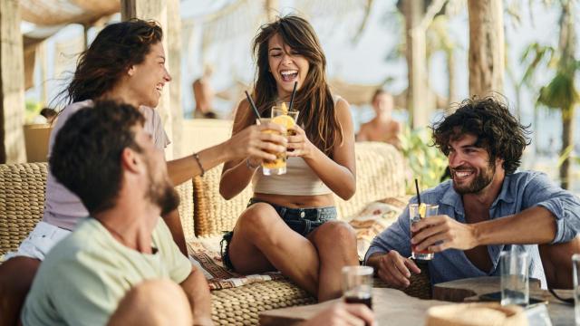 Amigos brindando en un chiringuito de playa.