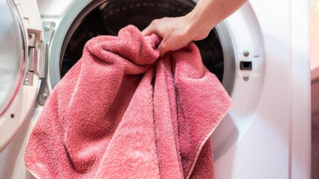 Metiendo la toalla en la lavadora.