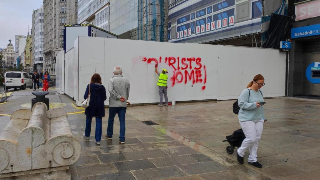 Técnico municipal borrando una pintada de 'Tourist Go Home'