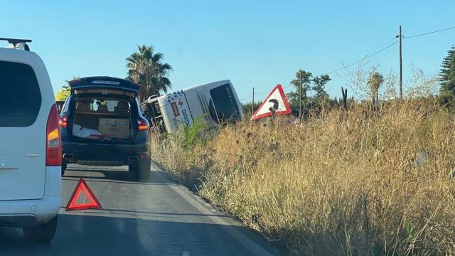 El autobús que cubre la ruta entre Sevilla y Bollullos de la Mitación volcado en la cuneta.