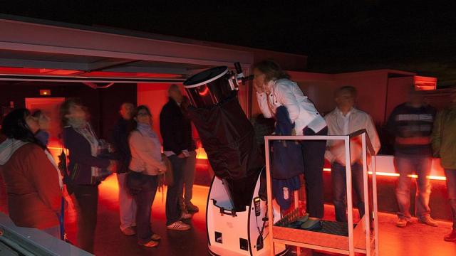 Personas observando por uno de los telescopios del Centro Astronómico de Tiedra