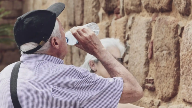 Un hombre bebe agua.