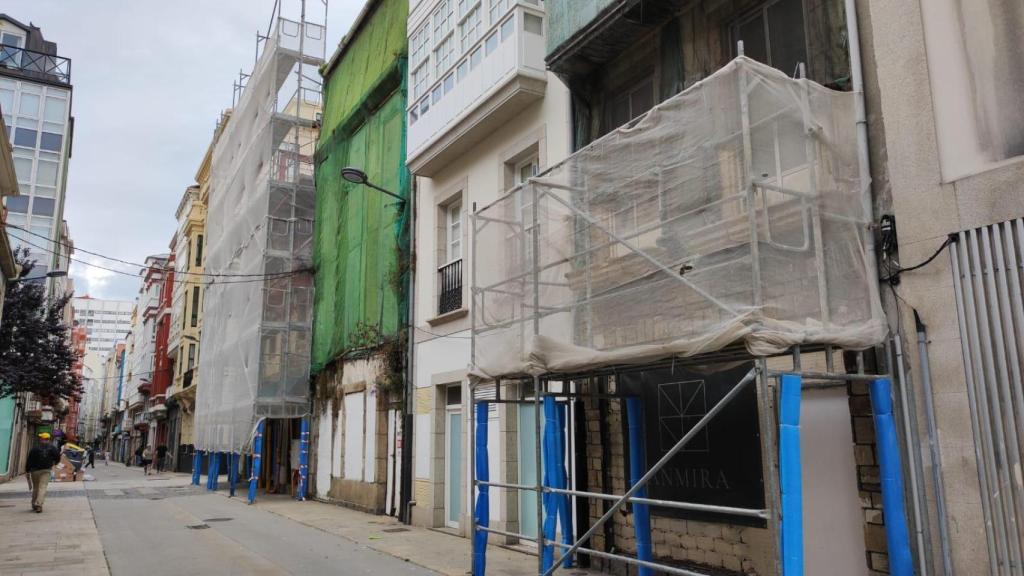 Dos bloques abandonados con andamios de obra en la calle Orzán.