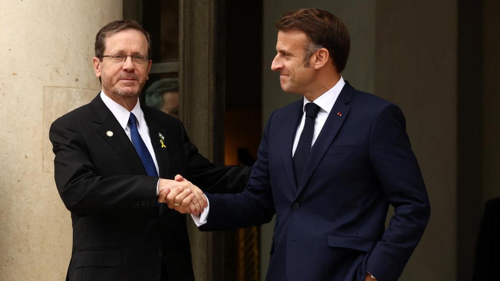Emmanuel Macron estrecha la mano del presidente israelí, Isaac Herzog.