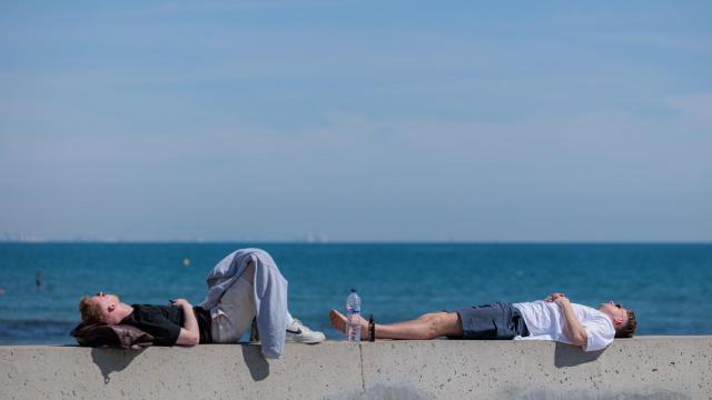 Dos personas tomando el sol en Alicante, en una imagen de archivo.