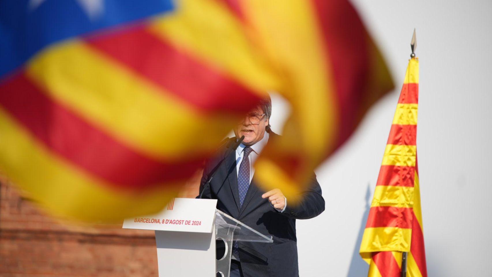El expresidente catalán Puigdemont, sobre el atril rodeado de banderas independentistas