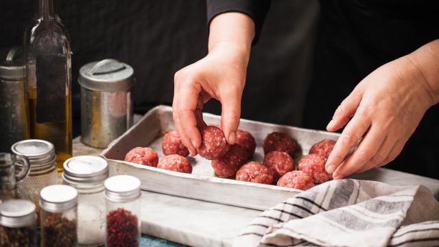 Una persona manipula unas albóndigas listas para cocinar
