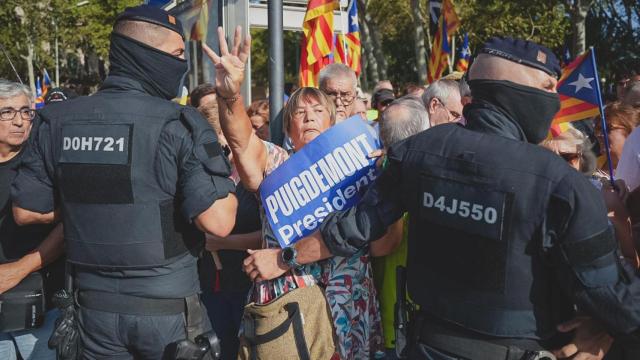 Los seguidores de Carles Puigdemont, rodeados de agentes de los Mossos, en el día de la investidura de Illa.