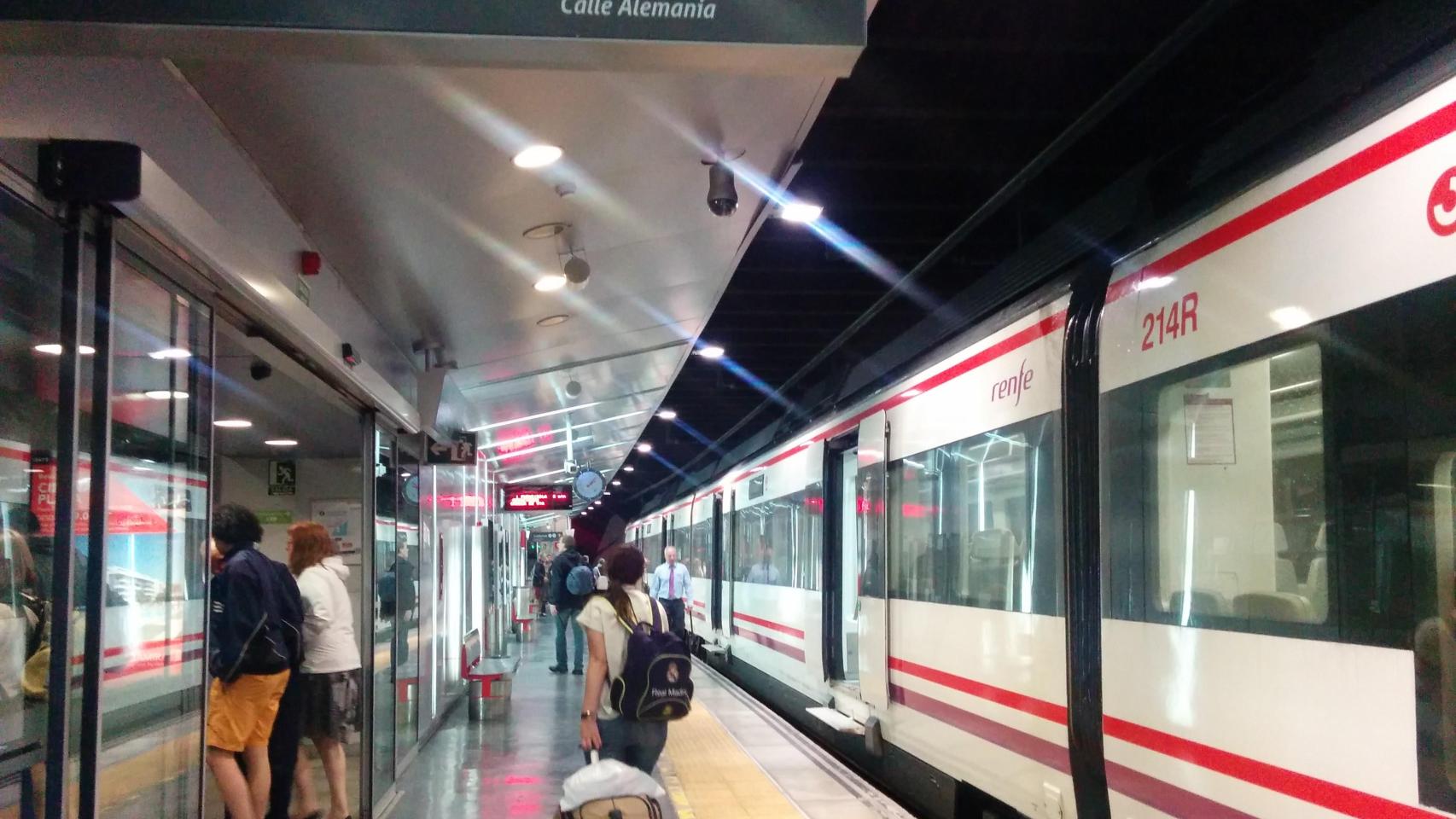 Una pasajera pasa junto a un tren de Cercanías de Málaga.