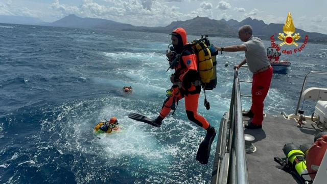 Buzos operan en el mar para buscar a los desaparecidos tras naufragar el yate de lujo en Sicilia.