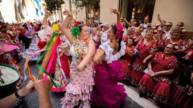Mujeres vestidas de flamencas cantan y bailan en la Feria del Centro.