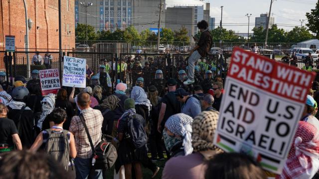 Los manifestantes se paran frente a la verja que da acceso al complejo donde se celebra la Convención.