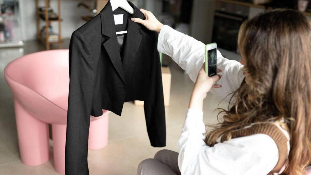 Una mujer hace una foto a una prenda de ropa para venderla.